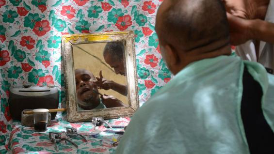Peluquería móvil. En la ciudad sobreviven oficios como el de este barbero, que atiende a sus clientes en plena calle. Peluquería móvil. En la ciudad sobreviven oficios como el de este barbero, que atiende a sus clientes en plena calle.