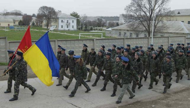 Disparos al aire. Militares ucranianos desfilaron en la base aérea de Belbek, cerca de Sebastopol, rodeada por uniformados rusos (AP).  