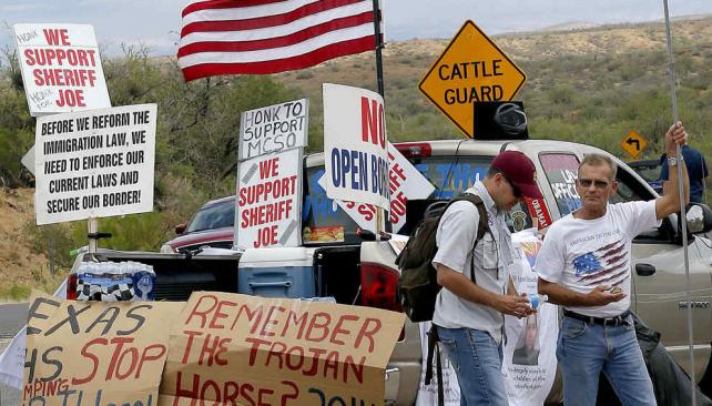 Xenófobos. Manifestantes exhibieron banderas de Estados Unidos y carteles en los que comparaban la llegada de chicos migrantes con el caballo de Troya (AP). 